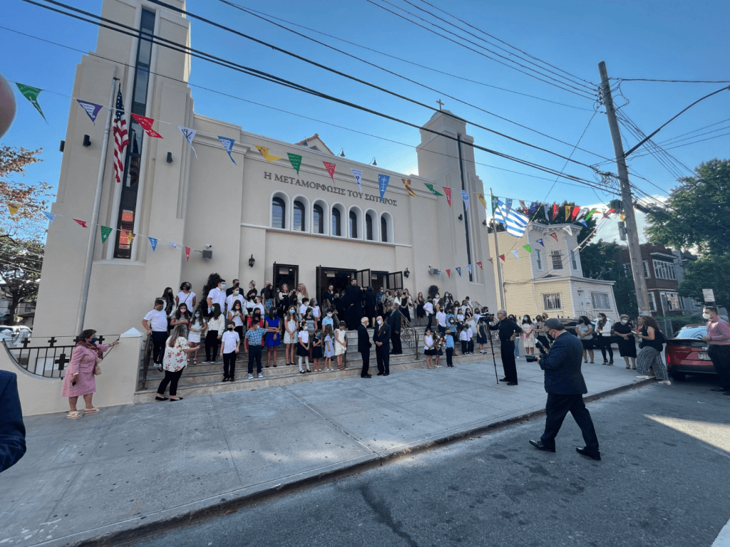 Community members gather outside of The transfiguration of Christ Greek Orthodox Church